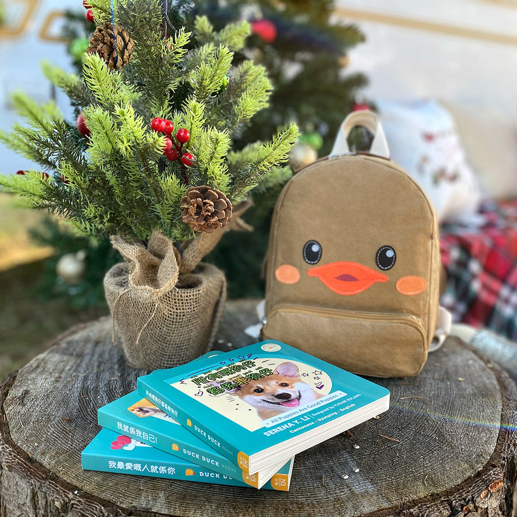Outdoor shot of Duck Duck Backpack three kids book gift bundle in Cantonese, I Love You More, All Puppies Are Good Puppies, I Am Me!