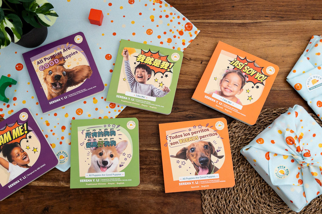 Duck Duck Books showcase of English, Traditional Chinese, and Spanish books, along with the GiftSwaddle